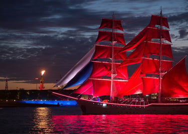 A majestic tall ship with illuminated scarlet sails at the Scarlet Sails festival in Saint Petersburg.