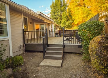 Completed backyard deck with stairs and black metal railing system