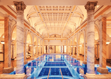 a large luxury indoor swimming pool with a blue tiles