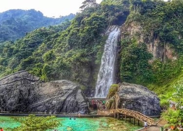 Air terjun Curug Bidadari setinggi 55 meter mengalir deras di Sentul Paradise Park, dikelilingi bebatuan besar dan jembatan i