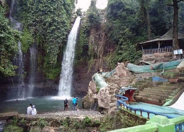Air terjun ganda Curug Luhur Bogor mengalir deras di antara bebatuan besar, dilengkapi dengan kolam renang buatan (waterpark)