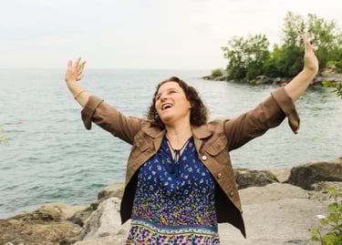 Natanya with her arms up and arms up, she is smiling
