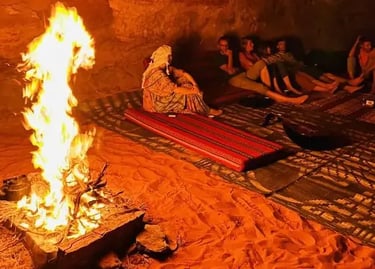 Guests sitting around the fire during bivouac camping in Wadi Rum