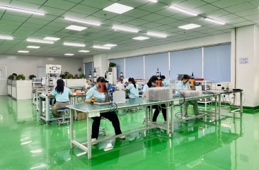 a group of people working on a table in a factory