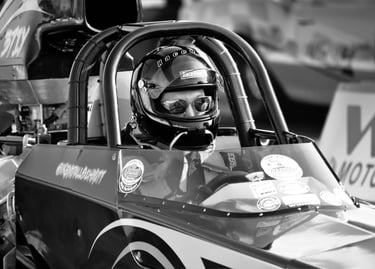 Black and White photo close up of top Fuel Dragster Driver in helmet and sunglasses