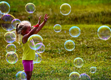 Little girl playing with bubbles