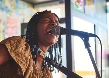 una mujer afro cantando con un micrófono