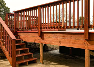 Completed residential wooden deck with stairs leading to a yard, built by Brewer Construction in Golden.