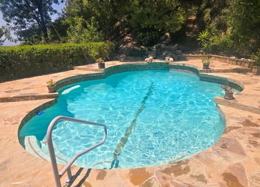 Natural stone pool with custom patio, cleaned and maintained by Piscus Pools – ideal for homeowners seeking nature-inspired 