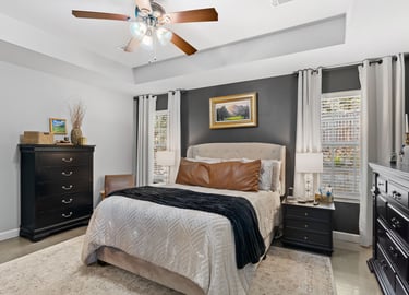 a bedroom with a bed and a ceiling fan