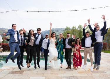 Jump shot degli sposi insieme agli amici durante il ricevimento del matrimonio