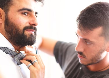 Preparativi dello sposo, un amico lo aiuta sistemandogli il papillon