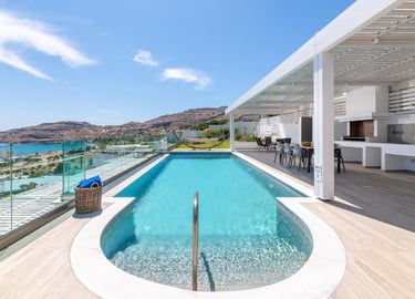 Luxury villa rooftop with infinity swimming pool, outdoor kitchen, and scenic coastal ocean views.
