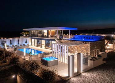 Luxury modern villa at night with illuminated infinity pool, hot tub, and outdoor terrace.