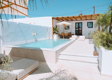 Luxury villa patio with a private infinity pool, sun loungers, and a shaded outdoor lounge area.