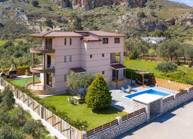 Luxury villa rental with a private swimming pool and garden nestled in a rocky mountain landscape.