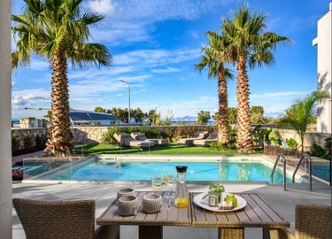 Luxury villa patio with a private pool, palm trees, and outdoor lounge chairs under a blue sky.