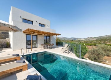 Modern luxury villa with a private infinity pool and patio overlooking a scenic valley landscape.