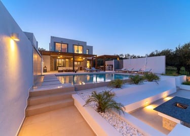 Luxury villa with private pool, outdoor patio, and fire pit at twilight.