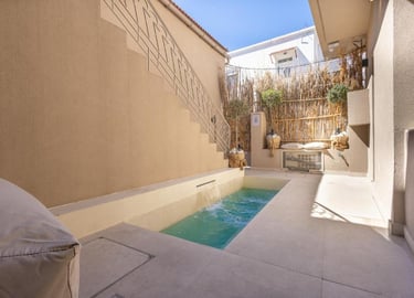 Luxury private outdoor plunge pool with stone patio and modern architectural wall features.