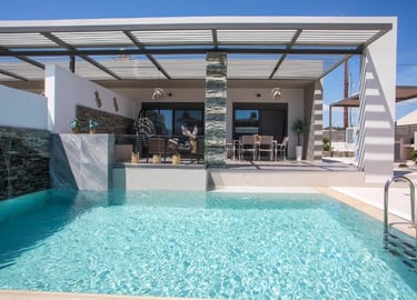 Modern luxury villa with a private swimming pool, outdoor dining area, and shaded pergola patio.