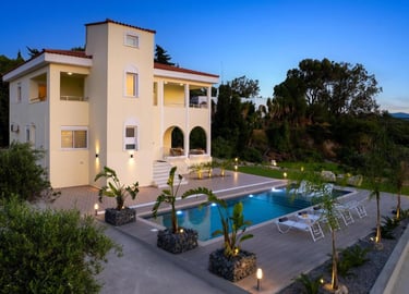 Luxury Mediterranean villa with a private swimming pool, sun loungers, and modern outdoor lighting at twilight.