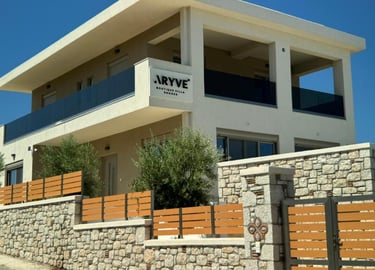 Luxury exterior of Aryve Boutique Villa in Rhodes featuring modern architecture and stone walls.