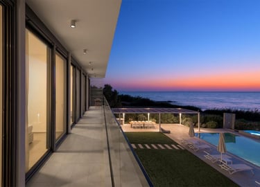 Luxury modern villa balcony with ocean views, swimming pool, and outdoor dining at sunset.