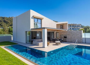 Modern luxury villa with a private turquoise swimming pool and outdoor lounge patio.