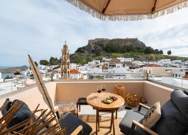 Luxury terrace view in Lindos, Rhodes overlooking the Acropolis and white village houses.