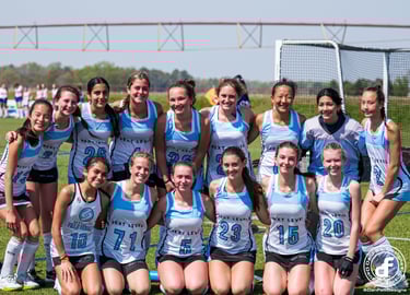 a group of girls field hockey players posing for a picture