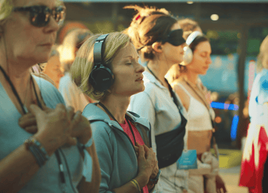 Laura the founder with a group of female participants, using headphones, during a meditation session
