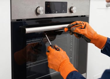 Technician fixing a refrigerator with tools in a bright, clean kitchen.