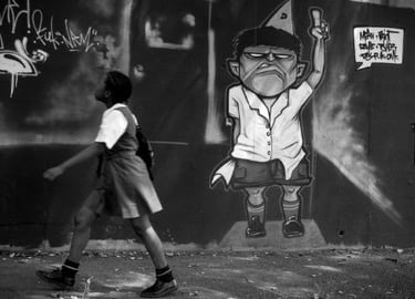 Schoolgirl passing a graffiti wall, from Martin Osner’s “On the Move” collection.
