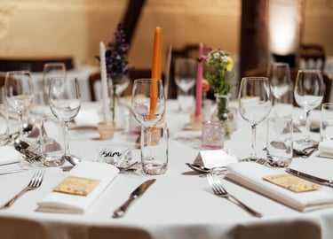 table with glasses  and name tags with colourful candles 