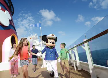 El Capitán Mickey Mouse saludando a una familia en la cubierta de un barco de Disney Cruise Line 