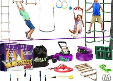Kids playing on a backyard ninja obstacle course training kit with climbing rope ladder and net.