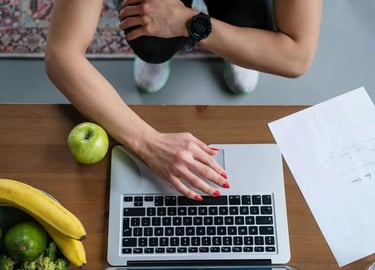 Pessoa usando notebook sobre mesa com frutas saudáveis e anotações
