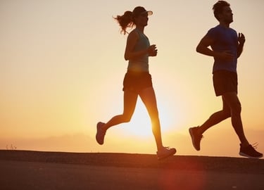a man and woman jogging in the sun