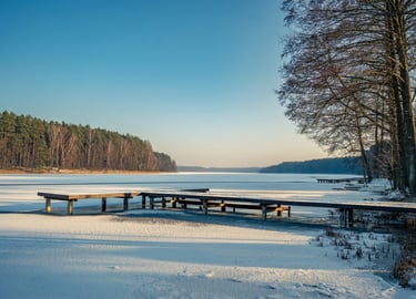 Canadian lake in spring with snow on dock and trees without leaves.