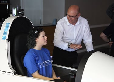 a lady in a simulator and a man