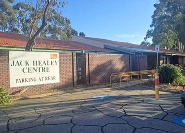 a parking lot with a car parked in front of Jack Healey Centre