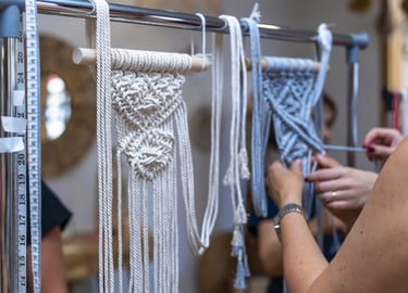 Personas haciendo decoraciones con macramé en un taller.