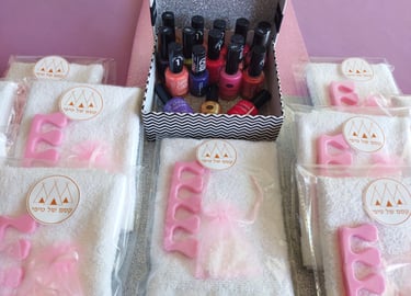 מסיבת יום הולדת ספא לילדות – מתחם טיפוח עם גיגיות להשריית רגליים, כיסאות ורודים ואווירת ספא מפנקת