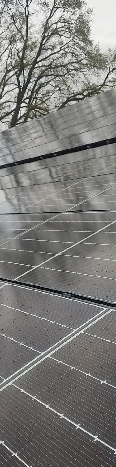 Ein Mann steht auf einem Dach mit Solarpaneelen.