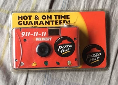 A packaged disposable film camera, in Pizza Hut's iconic colors and logo.