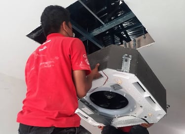 Suasana Aircond installer mounting new ceiling cassette AC unit.