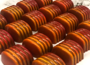 Handcrafted chocolates with cocoa butter decoration in vibrant colors luxury shine chocolates from ChocosCookiesCakes