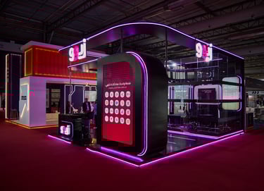 Modern neon-lit exhibition stand with purple LED accents and digital display at a trade show.
