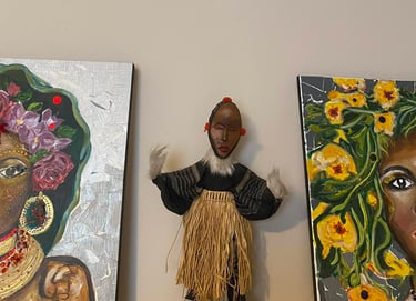 Handcrafted African tribal doll, dressed in a straw skirt, presented between two hybrid paintings by